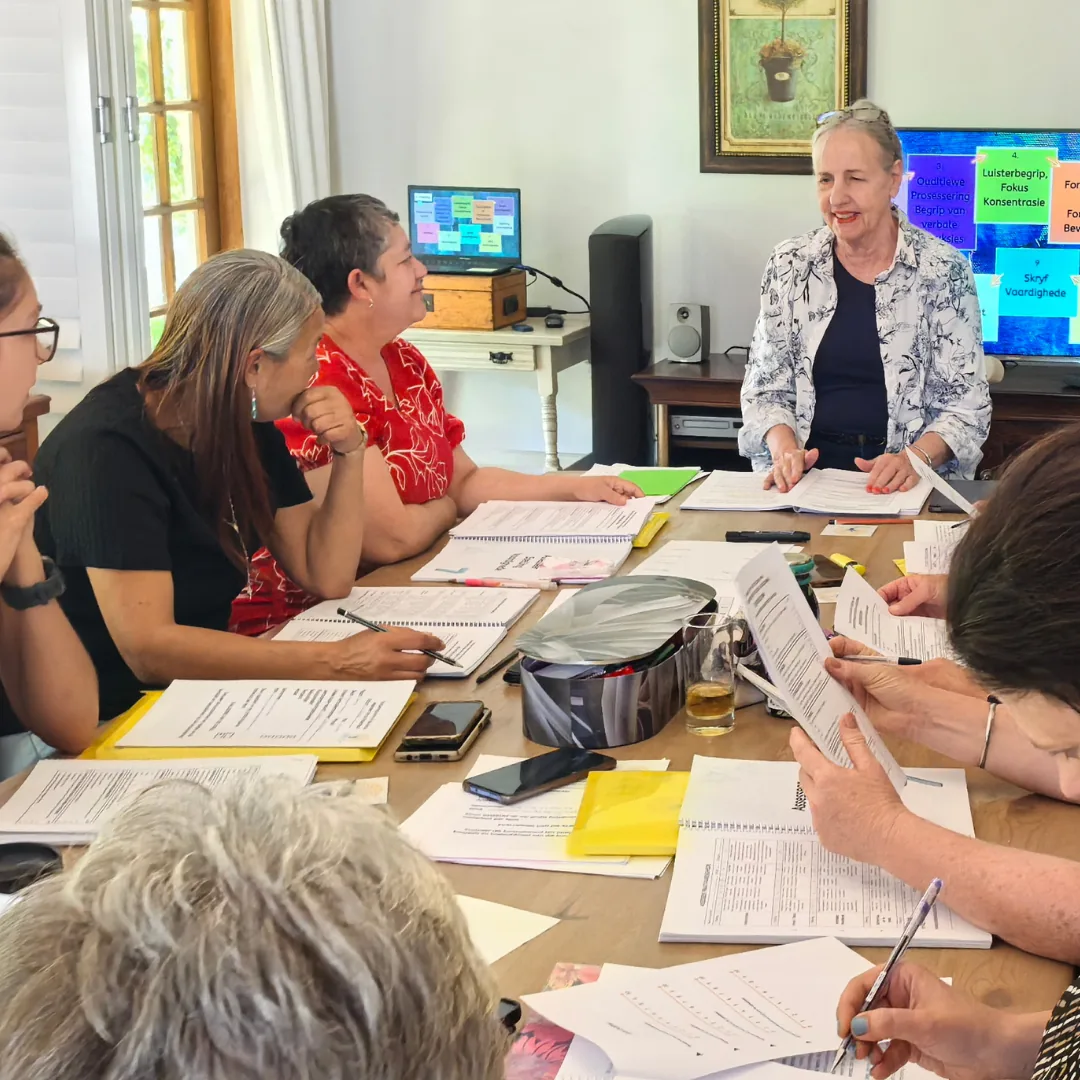 Annemarie leading a busy Yellow Tree training workshop around a table of educators